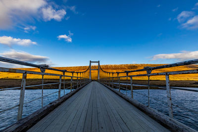 Bridge over calm blue sea against sky