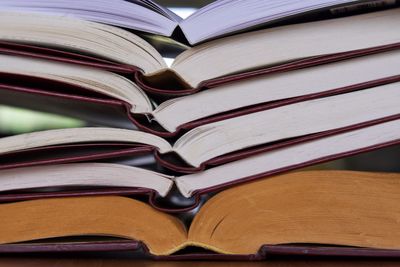 Stack of open hardcover books on table