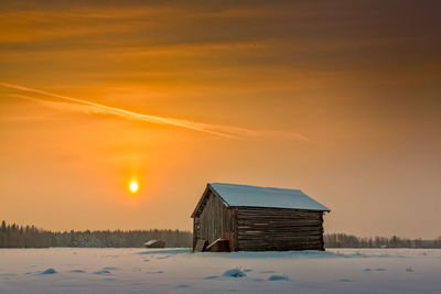 House against sky during winter at sunset