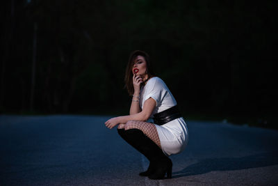 Side view of young woman looking away at night