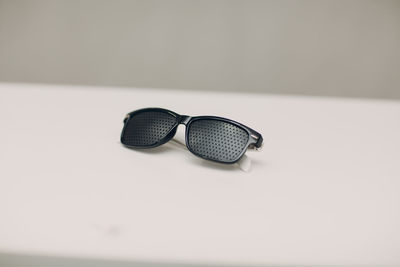 Close-up of eyeglasses on table against white background