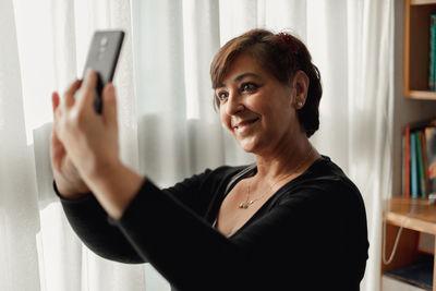 Portrait of smiling woman using mobile phone