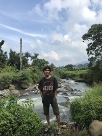 Portrait of young man standing against plants