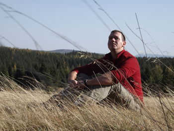 Young man sitting on field