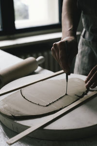 Craftswoman shaping clay at table in ceramics store