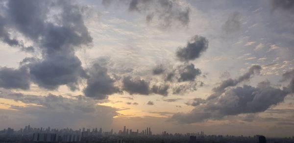 Panoramic view of silhouette buildings against sky during sunset