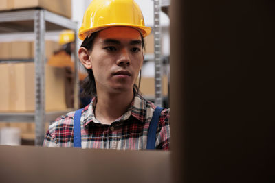 Portrait of boy wearing hardhat while standing outdoors