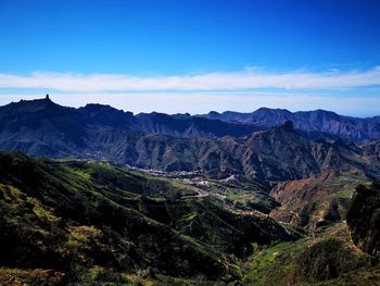 Scenic view of mountains against blue sky