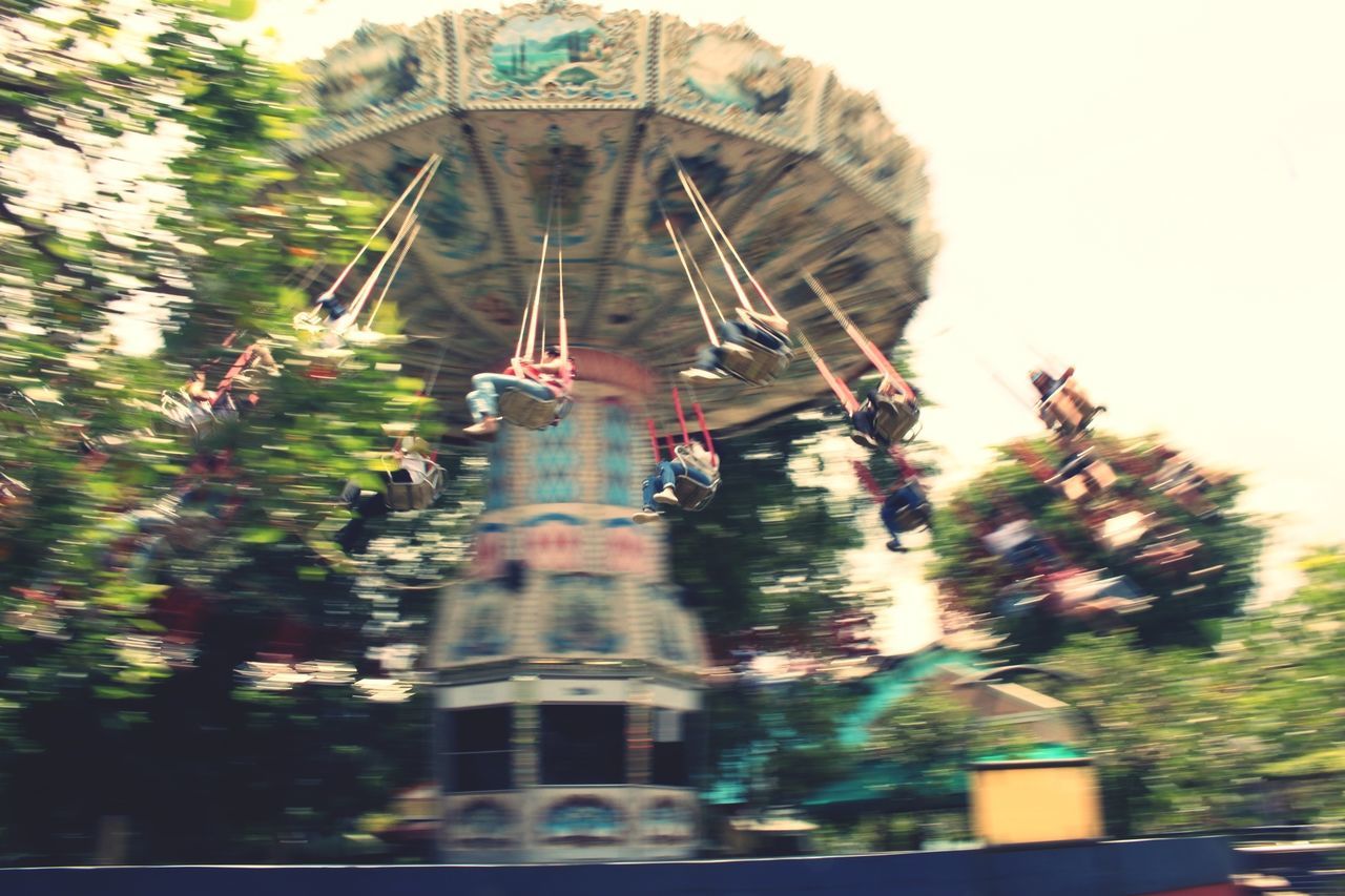 architecture, tree, built structure, building exterior, low angle view, outdoors, no people, motion, nature, water, sky, day, chain swing ride