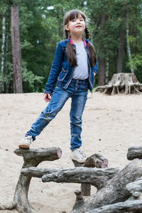 Full length of smiling girl standing on land