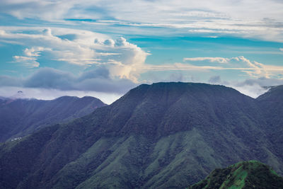 Mountain range with dramatic sunset sky and low clouds at evening