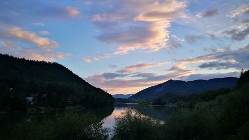 Scenic view of lake by mountains against sky