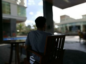 Rear view of man sitting on table