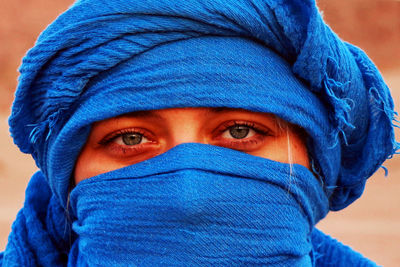 Close-up portrait of woman covered with blue scarf