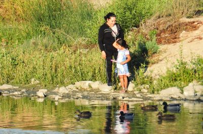 Full length of mother and daughter in lake