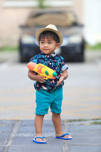 Full length of boy playing wit water gun