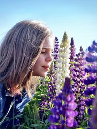 Portrait of girl smelling on purple flower