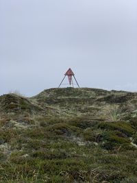 Lifeguard hut on field against sky