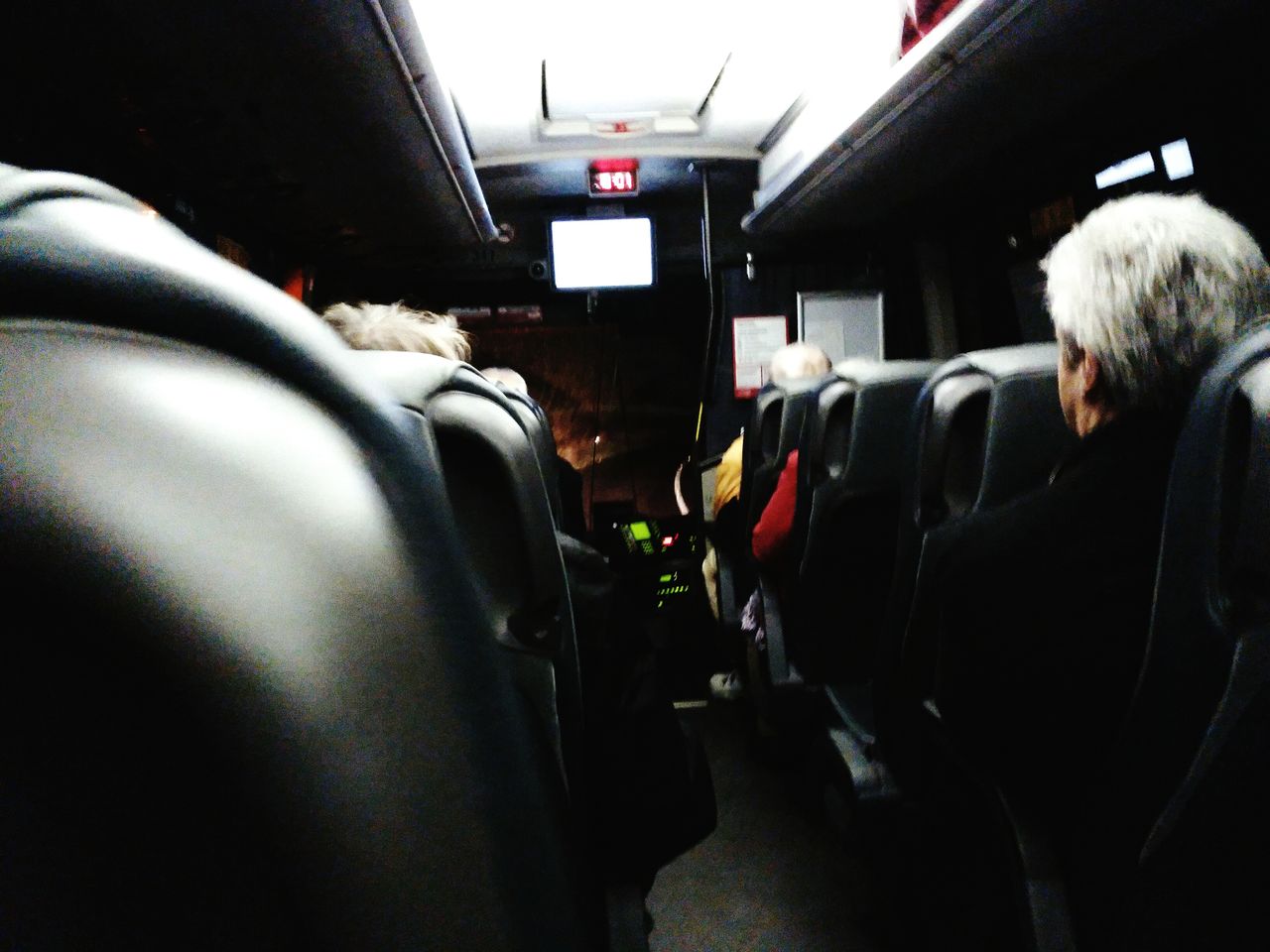 REAR VIEW OF PEOPLE TRAVELING IN BUS