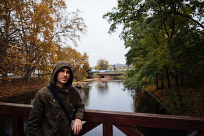 Man in hood standing on bridge, rain weather