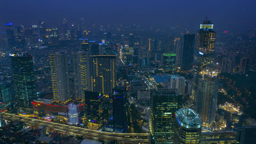 Aerial view of illuminated buildings in city at night