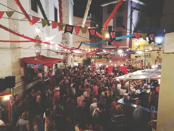 People at illuminated market in city at night