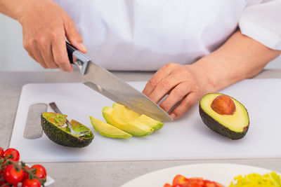 Midsection of man preparing food on cutting board