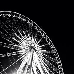 Low angle view of illuminated ferris wheel against sky at night