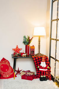 Christmas interior in the living room in red colors. on the table is a lamp, red mugs of cocoa