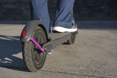 Low section of man standing on push scooter
