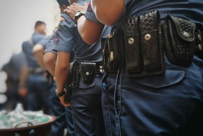 Midsection of man holding camera while standing outdoors