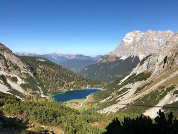 Scenic view of lake and mountains against clear sky