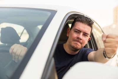 Close-up portrait of man sitting in car