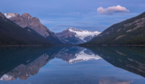 Scenic view of lake by mountains against sky