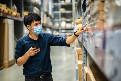 Man wearing mask working in warehouse