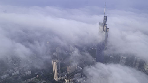 High angle view of communications tower amidst buildings in city