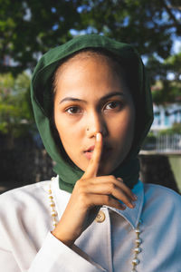 Portrait of beautiful young woman gesturing outdoors