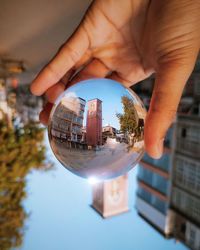 Close-up of person holding glass of building