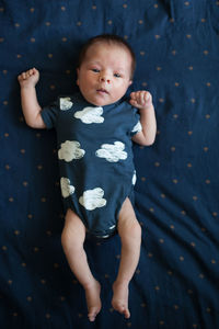 Cute newborn lying in the bed looking at the camera