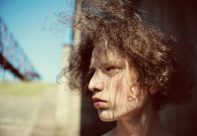 Close-up of woman looking away against sky