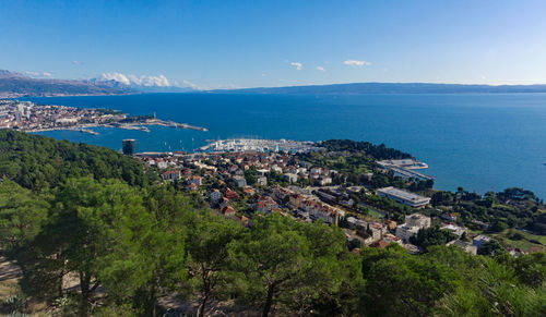 High angle view of townscape by sea against sky