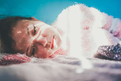 Close-up portrait of cute boy lying on bed