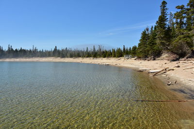 Scenic view of beach against clear blue sky