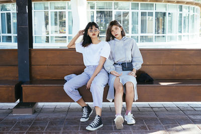 Portrait of friends sitting on bench