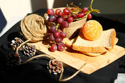 Close-up of grapes and orange fruits on table