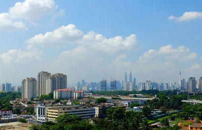 View of cityscape against cloudy sky