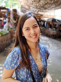 Portrait of smiling young woman standing in market