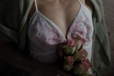 Midsection of woman holding rose bouquet