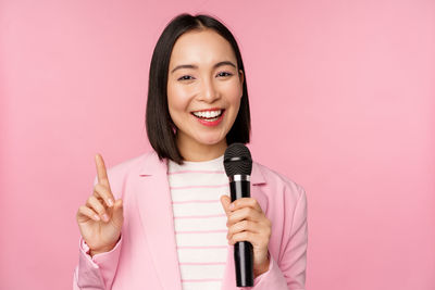 Portrait of young woman holding microphone