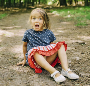 Portrait of cute girl sitting on field